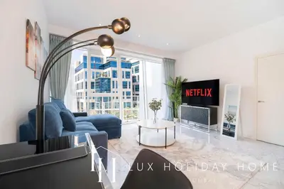 a living room with a blue couch and a large window at LUX The Pad Executive Suite Canal View 4 in Dubai