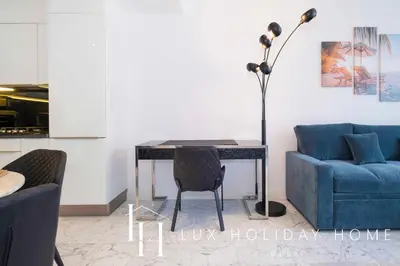 a living room with a table and a blue couch at LUX The Pad Executive Suite Canal View 4 in Dubai
