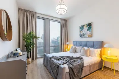 a bedroom with a bed and a large window at Hashtag Holiday Home - 1BDR Apartment with Canal View in Business Bay in Dubai