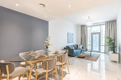 a living room with a table and chairs and a couch at Hashtag Holiday Home - 1BDR Apartment with Canal View in Business Bay in Dubai
