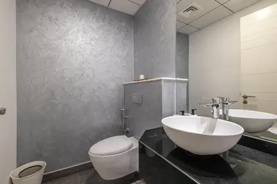 a bathroom with a white toilet and a sink at Hashtag Holiday Home - Excellent 1BDR with City View in Media city in Dubai