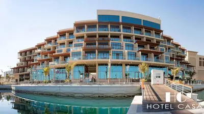 a hotel with a large building next to a body of water at Palm Jumeirah Upgraded & Cozy Boutique Apartment in Dubai