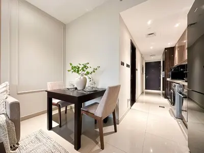 a kitchen and dining room with a table and chairs at Trophy - Downtown Scape Views Suite in Dubai