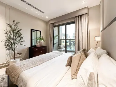 a bedroom with a large white bed and a window at Trophy - Downtown Scape Views Suite in Dubai