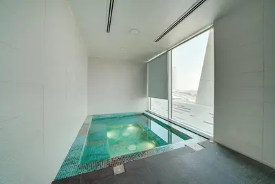 a swimming pool in a bathroom with a window at Lovely studio in Business Bay in Dubai