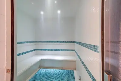 a walk in shower with a blue tiled floor at Lovely studio in Business Bay in Dubai