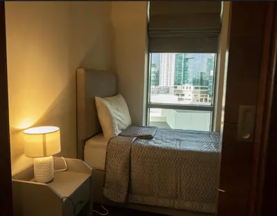 a small bedroom with a bed and a window at Luxury 3 BR - Direct View to Burj Khalifa in Dubai