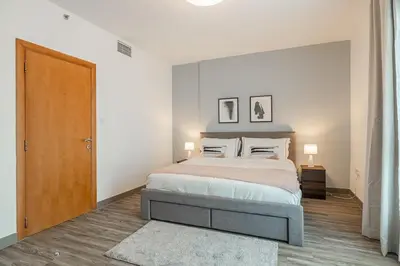 a bedroom with a bed and two pictures on the wall at 1BDR Apartment in Dubai Marina with Marina Views in Dubai