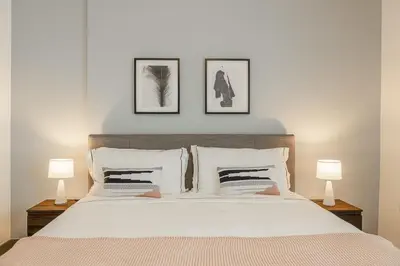 a bedroom with a large white bed with two lamps at 1BDR Apartment in Dubai Marina with Marina Views in Dubai