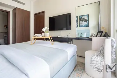 a bedroom with a bed and a tv and a chair at Frank Porter - Vera Residence in Dubai
