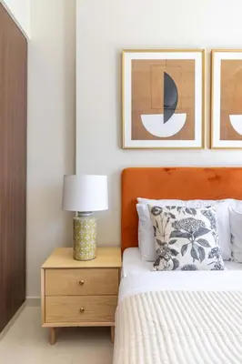 a bedroom with a bed and a night stand with a lamp at Frank Porter - Vera Residence in Dubai