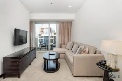 a living room with a couch and a tv at Marina Canal Views 1BR Minutes Away from Marina Mall, The Address Residences, Dubai Marina by Deluxe Holiday Homes in Dubai