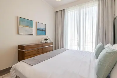 a bedroom with a white bed and a window at Spacious 2BDR in Creek Harbor with City View in Dubai