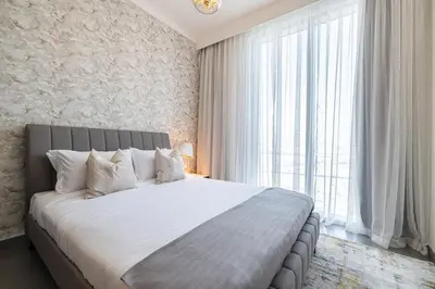 a bedroom with a large bed and a large window at Spacious 2BDR in Creek Harbor with City View in Dubai