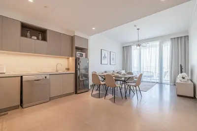 a kitchen and dining room with a table and chairs at Spacious 2BDR in Creek Harbor with City View in Dubai