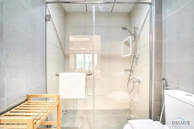a bathroom with a shower with a glass door at Refined 1BR at Bella Rose Barsha South by Deluxe Holiday Homes in Dubai
