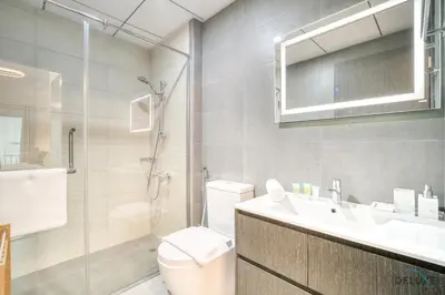a bathroom with a toilet and a sink and a shower at Refined 1BR at Bella Rose Barsha South by Deluxe Holiday Homes in Dubai