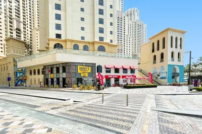an empty street in a city with tall buildings at bnbme - Luxury 1BR Marina View Apt w Balcony Pool Gym Access Near JBR Beach & Walk in Dubai