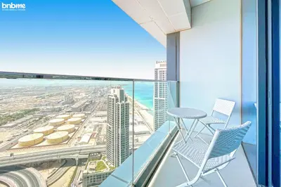 a balcony with chairs and a view of the city at bnbme - Luxury 1BR Marina View Apt w Balcony Pool Gym Access Near JBR Beach & Walk in Dubai