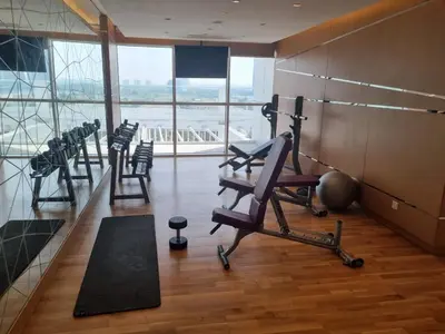 a gym with a row of exercise equipment in a building at Gala Guests - Carson Studio Collection in Dubai