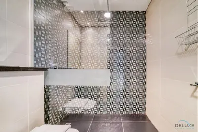 a bathroom with a shower with a bench in it at Sea Views from Living to Bedroom Perfect for Staycation, Dubai Marina by Deluxe Holiday Homes in Dubai