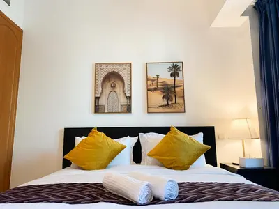 a bedroom with a bed with yellow pillows at La Buena Vida Holiday Homes - Exquisite Spacious Luxe 1BR Apt , Full Marina View, Kitchen, 5 Min to Beach, JBR and Marina in Dubai