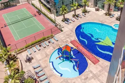 an overhead view of a pool with a tennis court at La Buena Vida Holiday Homes - Exquisite Spacious Luxe 1BR Apt , Full Marina View, Kitchen, 5 Min to Beach, JBR and Marina in Dubai