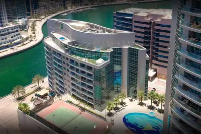 an aerial view of a large building with a tennis court at La Buena Vida Holiday Homes - Exquisite Spacious Luxe 1BR Apt , Full Marina View, Kitchen, 5 Min to Beach, JBR and Marina in Dubai