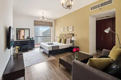 a living room with a bed and a couch at La Buena Vida Holiday Homes - Modern, Luxe & Spacious 4-Bed, Full Kitchen, near to Beach, Tram & Marina in Dubai