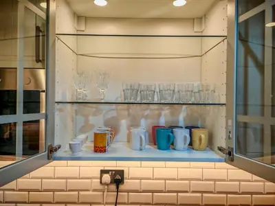 a shelf with cups and glasses on it at La Buena Vida Holiday Homes - Modern, Luxe & Spacious 4-Bed, Full Kitchen, near to Beach, Tram & Marina in Dubai