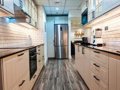 a large kitchen with a stainless steel refrigerator at La Buena Vida Holiday Homes - Modern, Luxe & Spacious 4-Bed, Full Kitchen, near to Beach, Tram & Marina in Dubai