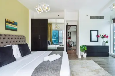 a bedroom with a large bed with two towels on it at Modern & Spacious 2-Bed Condo with Panoramic Lake Views, Dual Balconies, Steps from Dubai JLT Metro By 