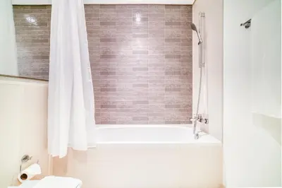 a bathroom with a white tub and a white shower curtain at Emaar Beach Front 2BR with Sea & Marina Skyline Views in Dubai