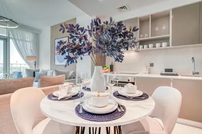 a dining room and living room with a table and chairs at Emaar Beach Front 2BR with Sea & Marina Skyline Views in Dubai