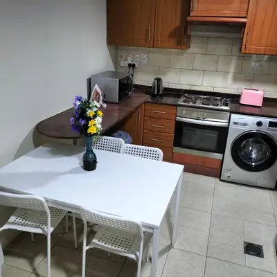 a kitchen with a table with a vase of flowers on it at Amazing apartment 2 bed rooms in Tecom 6 pax in Dubai