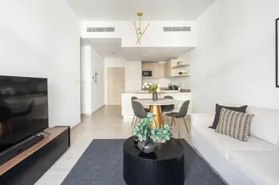a living room with a white couch and a table at Frank Porter - Belgravia 3 in Dubai