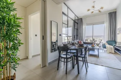 a dining room and living room with a table and chairs at GuestReady - Breath of Fresh Air in Dubai Hills in Dubai
