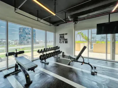 a gym with a row of treadmills and machines at GuestReady - Breath of Fresh Air in Dubai Hills in Dubai