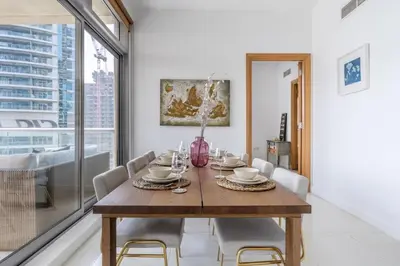 a dining room with a wooden table and chairs at GuestReady - Skyview Home with Marina View in Dubai