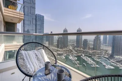 a balcony with a table and chairs and a view of a harbor at GuestReady - Skyview Home with Marina View in Dubai
