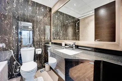 a bathroom with a toilet and a sink and a mirror at Amazing Burj Khalifa view from Brand new apartment in Dubai