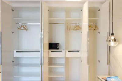 a glass walk in closet with white shelves at Livbnb-Upgraded 2BR plus Maid's Room with Sea View in Dubai