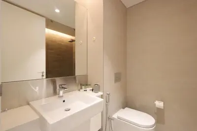 a bathroom with a sink and a toilet and a mirror at Livbnb-Upgraded 2BR plus Maid's Room with Sea View in Dubai