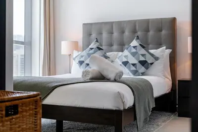 a bedroom with a large bed with blue and white pillows at Cute 1BR - Dubai Marina Views - Walk 9min to Beach in Dubai