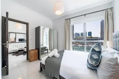 a bedroom with a large bed and a large window at Cute 1BR - Dubai Marina Views - Walk 9min to Beach in Dubai