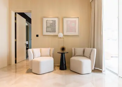 two white chairs and a table in a room at Maison Privee - Luxury Sea View Apt in FIVE Resort on The Palm in Dubai