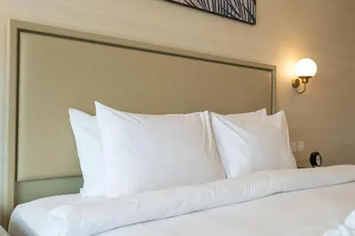 a bed with white pillows in a hotel room at Palm Tower where Luxury & View meet in one place in Dubai