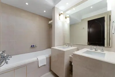 a bathroom with two sinks and a tub and a mirror at Maison Privee - Elite Apt Connected to Dubai Mall & Burj Khalifa in Dubai