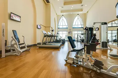 a gym with a row of treadmills and machines at Maison Privee - Elite Apt Connected to Dubai Mall & Burj Khalifa in Dubai