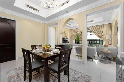a dining room and living room with a table and chairs at Maison Privee - Elite Apt Connected to Dubai Mall & Burj Khalifa in Dubai